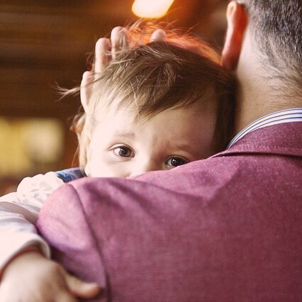 Un bambino tra le braccia del padre.